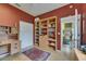 Cozy office space featuring a wooden desk, built-in bookcase, and warm red walls at 17711 Hampshire Oak Dr, Tampa, FL 33647