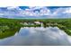 Scenic view of the tranquil pond with a fountain, surrounded by lush trees and a clubhouse at 17711 Hampshire Oak Dr, Tampa, FL 33647