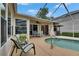 A view of the pool with outdoor seating and a barbecue grill at 17711 Hampshire Oak Dr, Tampa, FL 33647