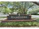 Hampshire community sign with brick base and colorful flowers at 17711 Hampshire Oak Dr, Tampa, FL 33647