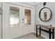 Elegant entryway with decorative glass double doors, round mirror and accent table at 1960 Montana Ne Ave, St Petersburg, FL 33703