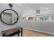 Inviting entryway featuring a round mirror, wooden console table, and a glimpse into the modern kitchen at 1960 Montana Ne Ave, St Petersburg, FL 33703