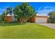 Beautifully landscaped home with a lush green lawn, mature trees, and a welcoming two-car garage at 1960 Montana Ne Ave, St Petersburg, FL 33703