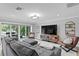 Stylish living room with a gray sectional sofa, eclectic TV stand, and sliding glass doors to outdoor area at 1960 Montana Ne Ave, St Petersburg, FL 33703