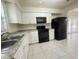 Clean kitchen featuring white cabinets and black appliances at 206 Circle Hill Dr, Brandon, FL 33510
