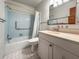Cozy bathroom featuring a tub with blue tile surround, vanity, and matching tile flooring at 230 Portree Dr, Dunedin, FL 34698