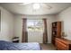 A cozy bedroom with soft light, featuring a bed with blue covers, with view outside at 230 Portree Dr, Dunedin, FL 34698