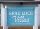 Community sign for Skye Loch Villas, a 55+ community on Patricia Avenue at 230 Portree Dr, Dunedin, FL 34698