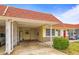 Charming condo featuring a red roof, well-manicured landscaping, and a convenient carport at 230 Portree Dr, Dunedin, FL 34698