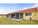 A cozy home with a red roof and screened lanai set on a well-maintained lawn under a sunny sky at 230 Portree Dr, Dunedin, FL 34698