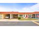 Charming condo featuring a red roof, well-manicured landscaping, and a convenient carport at 230 Portree Dr, Dunedin, FL 34698