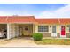Charming condo featuring a red roof, well-manicured landscaping, and a convenient carport at 230 Portree Dr, Dunedin, FL 34698
