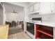 Kitchen with white cabinets, black appliances, open floor plan to dining area at 230 Portree Dr, Dunedin, FL 34698