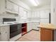 Kitchen features white cabinets, tile flooring and black appliances at 230 Portree Dr, Dunedin, FL 34698
