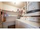 Convenient laundry room including washer, dryer, water heater, and ample shelving at 230 Portree Dr, Dunedin, FL 34698