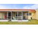 A screened patio shows green chairs and a chaise lounge beside the home with a red roof on a sunny day at 230 Portree Dr, Dunedin, FL 34698