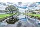Scenic water view with lush landscaping and serene canal reflecting sky and trees at 230 Portree Dr, Dunedin, FL 34698