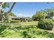 Spacious yard featuring a lush lawn, mature landscaping and the rear of the home at 2724 Ashwood Ct, Clearwater, FL 33761