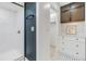 Modern bathroom featuring subway tile shower, blue accent wall, and custom vanity with storage at 2724 Ashwood Ct, Clearwater, FL 33761