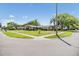 Charming single-story home with a well-manicured lawn and mature trees on a sunny day at 2724 Ashwood Ct, Clearwater, FL 33761