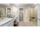 Modern bathroom featuring dual vanities, a glass-enclosed shower, and elegant fixtures at 29524 Zupetta Ln, Wesley Chapel, FL 33543