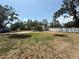 Exterior showcasing a spacious backyard with a white fence, gravel landscaping, and mature trees at 3000 58Th S Ave, St Petersburg, FL 33712