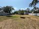 Wide shot of the backyard showing the fence, grass, and mature trees surrounding the home at 3000 58Th S Ave, St Petersburg, FL 33712
