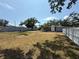Spacious backyard featuring mature trees, a white fence, and a single-story home with landscaping at 3000 58Th S Ave, St Petersburg, FL 33712