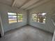 Bedroom with exposed beam ceiling, two windows and view of lush greenery outside at 3000 58Th S Ave, St Petersburg, FL 33712