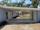 Spacious carport area showing its concrete floor leading to the home's dual entry doors at 3000 58Th S Ave, St Petersburg, FL 33712