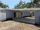 Home's front facade showcasing a practical carport with a concrete floor and manicured flower beds at 3000 58Th S Ave, St Petersburg, FL 33712