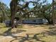 Inviting single-story home featuring a light blue facade complemented by well-maintained landscaping and mature trees at 3000 58Th S Ave, St Petersburg, FL 33712