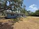Charming light blue house with a screened porch, surrounded by mature trees providing shade and a private outdoor space at 3000 58Th S Ave, St Petersburg, FL 33712
