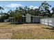 Back of the home featuring a white brick accent wall and surrounded by mature trees at 3000 58Th S Ave, St Petersburg, FL 33712