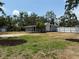 Backyard view showcasing a screened porch, landscaping, mature trees, and a storage shed at 3000 58Th S Ave, St Petersburg, FL 33712