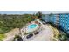 Aerial view showcasing the pool, parking and the condo building surrounded by lush greenery at 3315 58Th S Ave # 605, St Petersburg, FL 33712