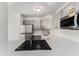 Modern kitchen featuring stainless steel appliances, gray cabinets, subway tile backsplash, and a cooktop at 3315 58Th S Ave # 605, St Petersburg, FL 33712