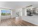 Bright living room with wood floors, balcony, and open kitchen with gray cabinets and modern lighting at 3315 58Th S Ave # 605, St Petersburg, FL 33712