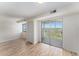 Bright, airy living room with wood floors and sliding glass doors leading to a balcony with treetop views at 3315 58Th S Ave # 605, St Petersburg, FL 33712