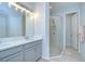 Modern bathroom with double vanity, glass-enclosed shower, and neutral finishes, offering a clean and functional space at 33518 Castaway Loop, Wesley Chapel, FL 33543