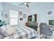 Cozy bedroom featuring a large TV, a gray plaid comforter and a modern desk setup at 33518 Castaway Loop, Wesley Chapel, FL 33543