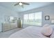 Bright bedroom with a large window, dresser, and neutral tones, offering a serene and spacious retreat at 33518 Castaway Loop, Wesley Chapel, FL 33543