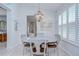 Elegant dining room featuring a chandelier, plantation shutters, and seating for four at 33518 Castaway Loop, Wesley Chapel, FL 33543