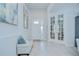 Bright entryway features a bench, decorative artwork, and double doors leading to another room at 33518 Castaway Loop, Wesley Chapel, FL 33543