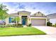 Inviting single-story home featuring a well-manicured lawn, blue door, and a two-car garage at 33518 Castaway Loop, Wesley Chapel, FL 33543