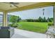 Covered patio with a view of the lush green yard and landscaping beyond at 33518 Castaway Loop, Wesley Chapel, FL 33543