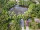Stunning aerial view of a lakefront property with private pools surrounded by lush greenery and mature trees at 3428 Valley Ranch Dr, Lutz, FL 33548