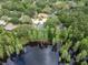 Aerial view of a neighborhood featuring lakefront properties surrounded by lush greenery and mature trees at 3428 Valley Ranch Dr, Lutz, FL 33548