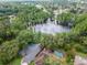Aerial view showcasing a home nestled near a lake surrounded by lush greenery and a swimming pool at 3428 Valley Ranch Dr, Lutz, FL 33548