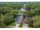 Aerial view of home with lake, lush trees, and well-manicured lawn in a peaceful community at 3428 Valley Ranch Dr, Lutz, FL 33548